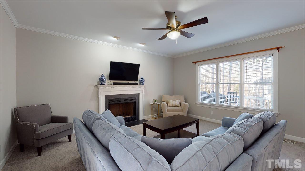 4708 Alistar Court Raleigh, NC 27612 - Photo 8 of 30 a living room with furniture a flat screen tv and a fireplace