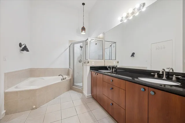 a spacious bathroom with a tub sink and mirror