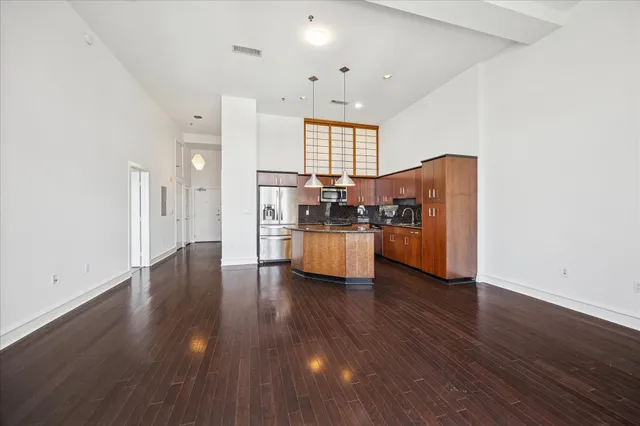 a kitchen with stainless steel appliances wooden floors and white walls