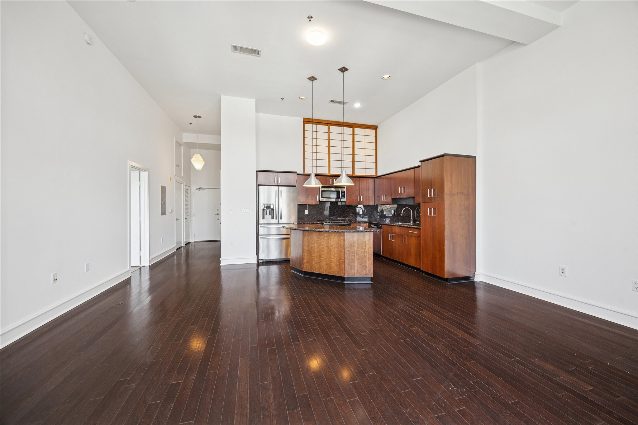 3311 Yupon Street, Unit 609 Houston, TX 77006 - Photo 9 of 16 a kitchen with stainless steel appliances wooden floors and white walls