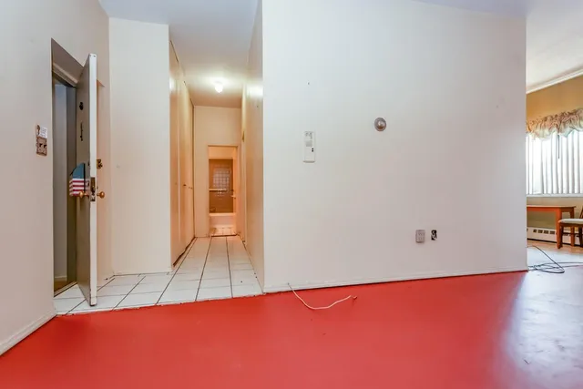 a view of a room with wooden floor and a bathroom