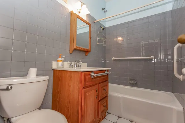 a bathroom with a granite countertop toilet a sink and bathtub