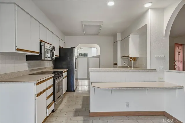 a kitchen with stainless steel appliances a sink stove and cabinets