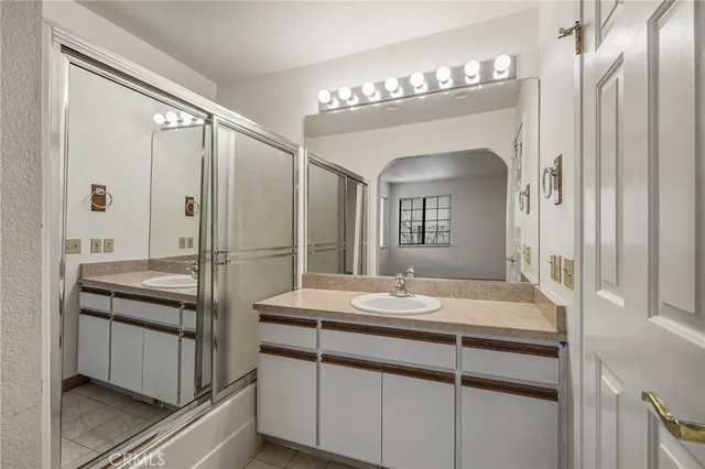 a bathroom with a granite countertop sink a mirror and a shower