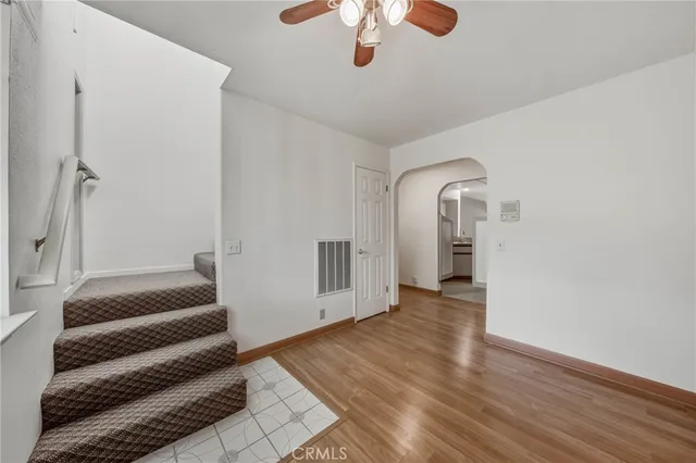 a view of a livingroom with wooden floor and a ceiling fan