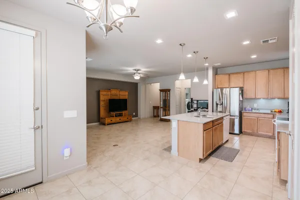 a large kitchen with a refrigerator a stove top oven and a sink