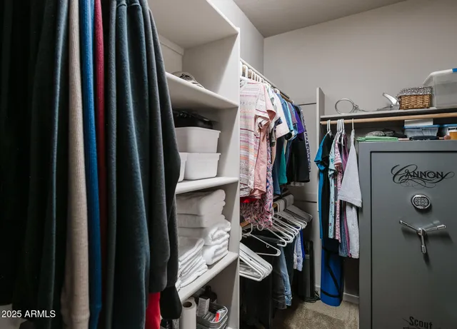 a view of walk in closet with clothes and shoes
