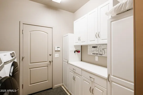 a view of washer and dryer with white cabinet