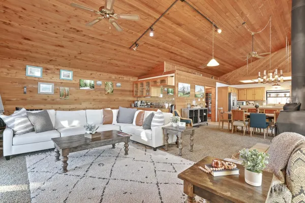 a kitchen with stainless steel appliances granite countertop a table chairs a refrigerator and a sink