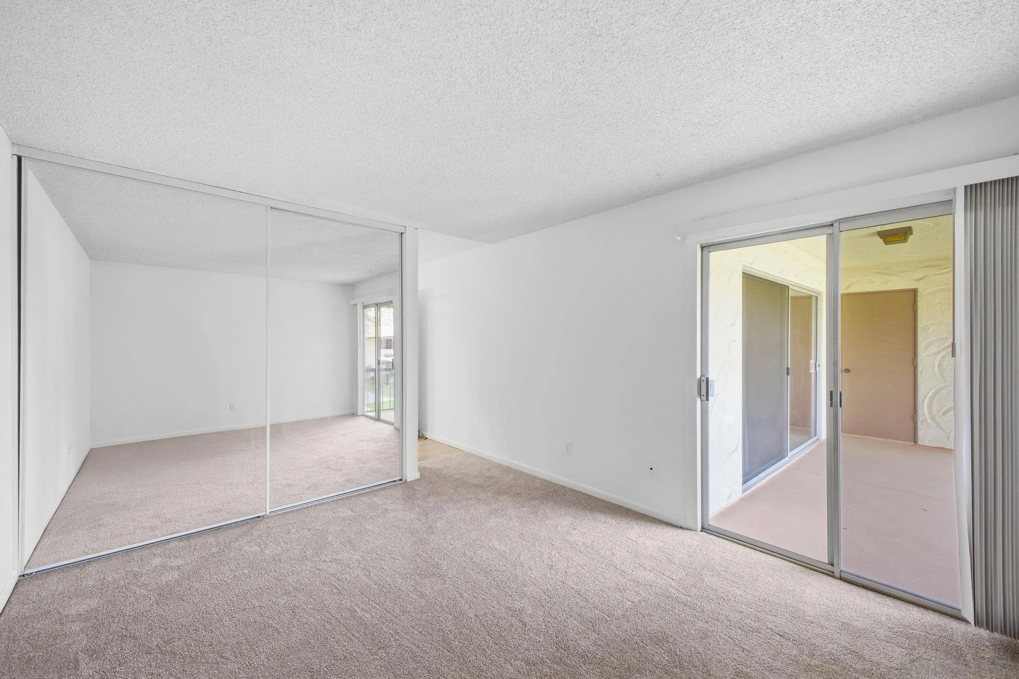 6019 Rancho Mission Road, Unit 204 San Diego, CA 92108 - Photo 19 of 38 Spacious primary bedroom with access to patio & floor-ceiling closet