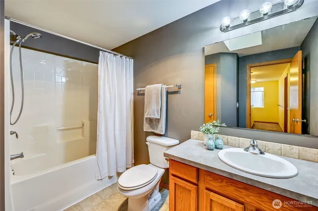a bathroom with a granite countertop sink toilet mirror and shower