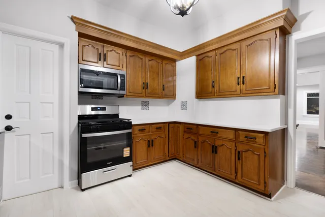 a kitchen with stainless steel appliances granite countertop a stove a sink and a microwave