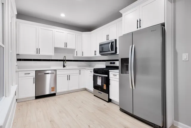 a kitchen with stainless steel appliances a refrigerator sink and cabinets