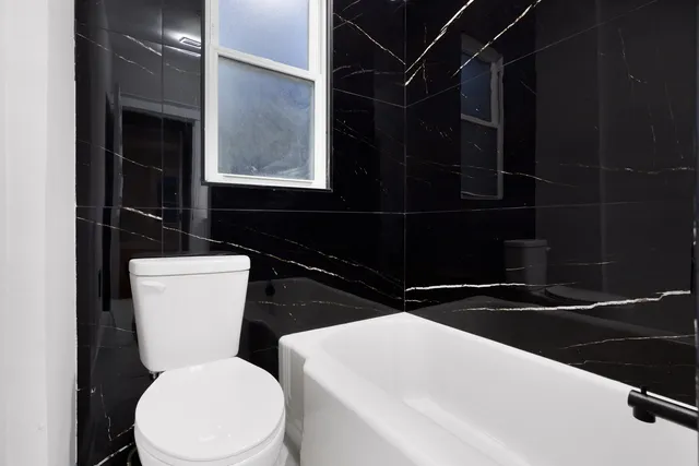 a bathroom with a toilet a sink and a mirror