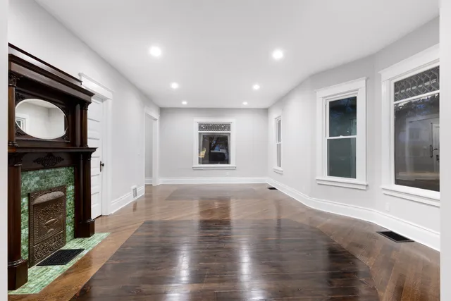 a view of an empty room with a fireplace and a window
