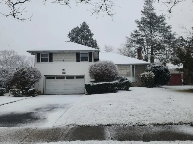 a front view of a house with a yard covered in snow