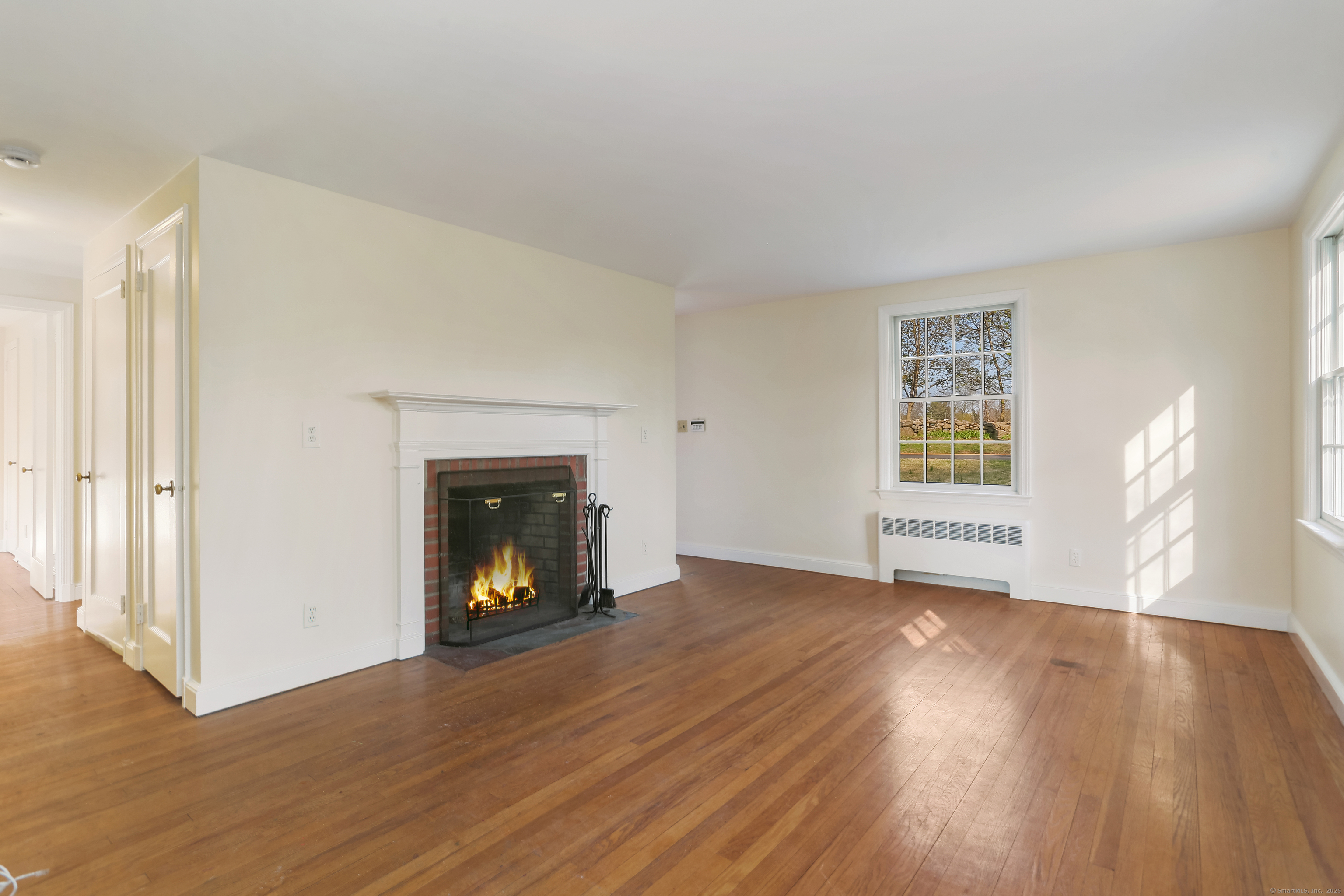 219 Hollow Tree Ridge Road Darien, CT 06820 - Photo 4 of 27 Sunny living room with hard wood floors and wood burning fireplace.