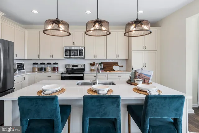 a kitchen with stainless steel appliances a table chairs and a stove