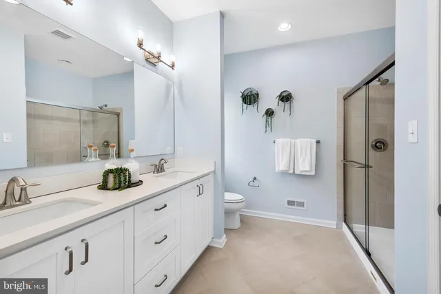 a bathroom with a double vanity sink toilet and shower