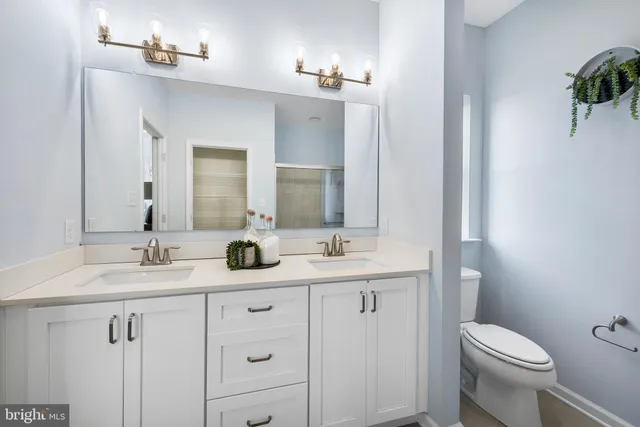 a bathroom with a toilet a sink a vanity and mirror