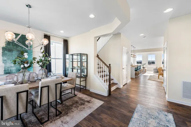 a view of a dining room and livingroom with furniture wooden floor a chandelier