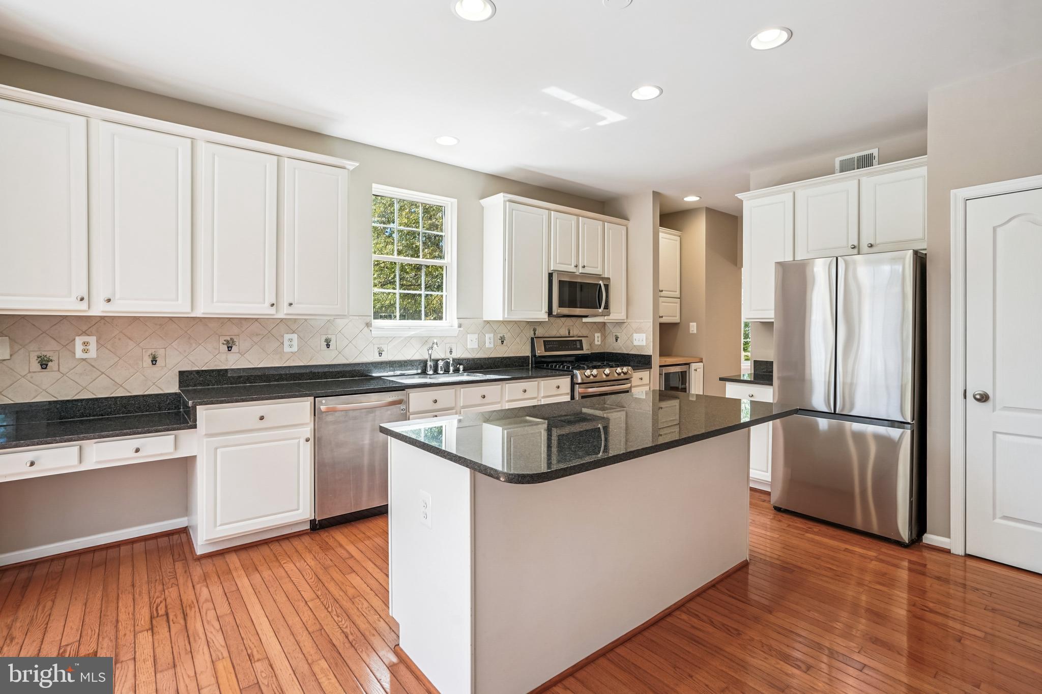 26096 Flintonbridge Drive Chantilly, VA 20152 - Photo 12 of 69 a kitchen with a refrigerator a sink and wooden cabinets