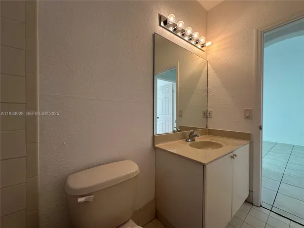 a bathroom with a granite countertop sink a toilet and a mirror