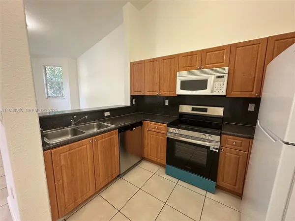 a kitchen with stainless steel appliances granite countertop a stove and a microwave