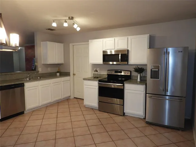 a kitchen with a sink appliances and cabinets