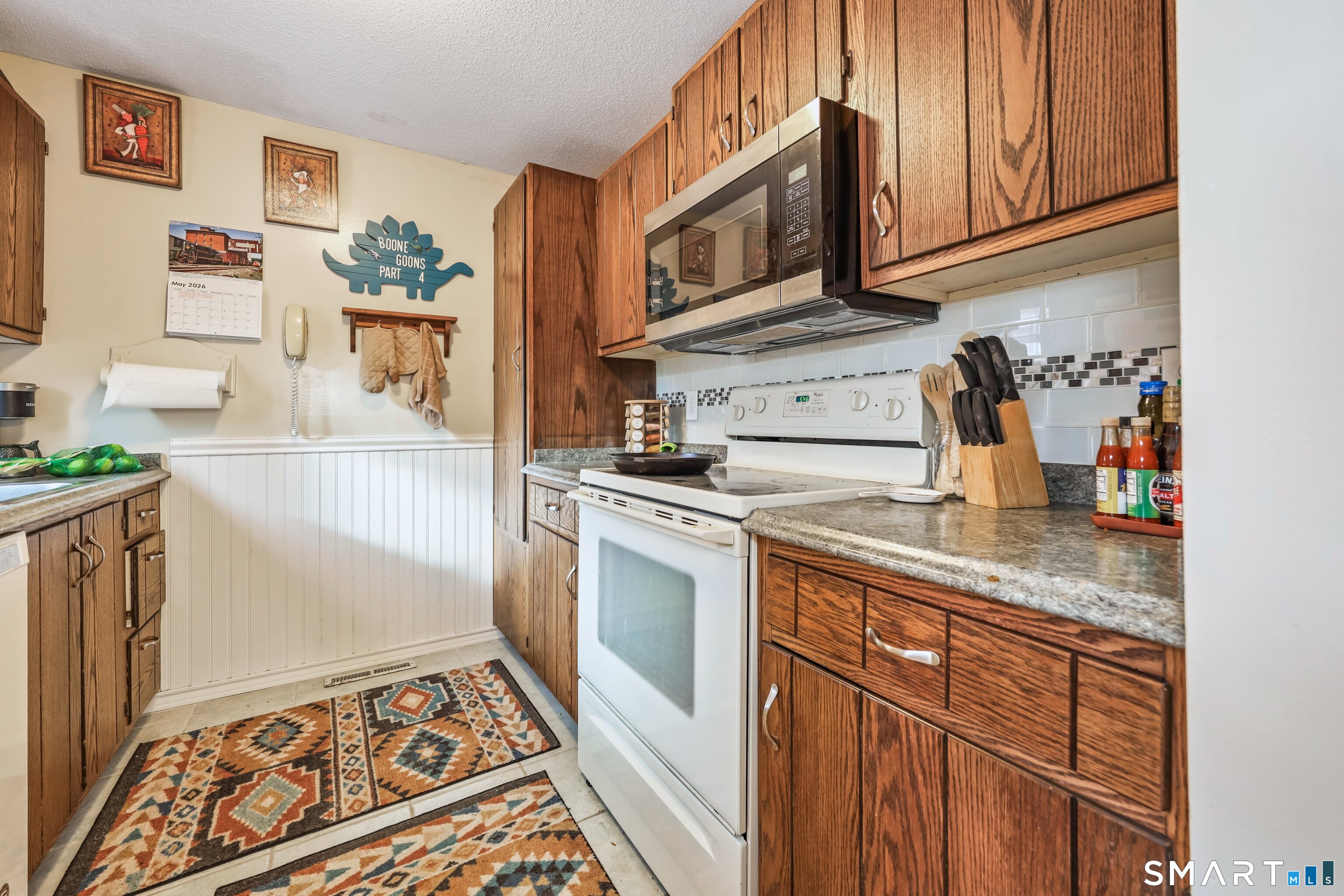 349 Allen Road, Unit 34C Torrington, CT 06790 - Photo 10 of 31 a kitchen with stainless steel appliances granite countertop a stove a sink and a microwave