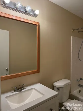 a bathroom with a sink a toilet and a mirror