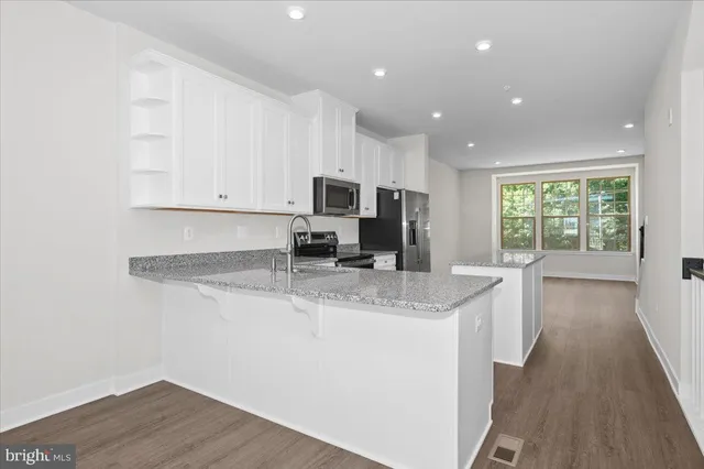 a kitchen with white cabinets and stainless steel appliances