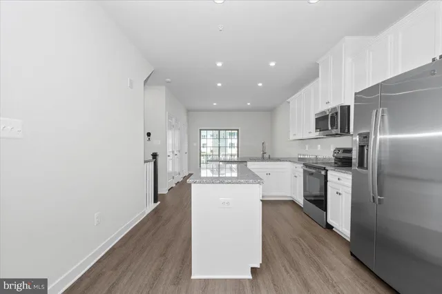 a kitchen with granite countertop a sink stove and refrigerator