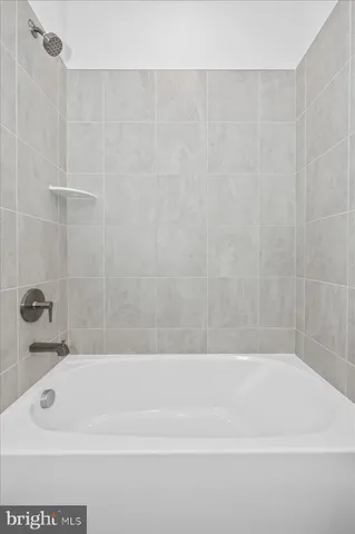 a view of a white house with a yard and table and chairs under an umbrella