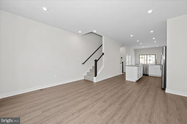 a kitchen with stainless steel appliances granite countertop a sink a stove a microwave a refrigerator a window and cabinets