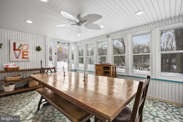a dining room with wooden floor and window