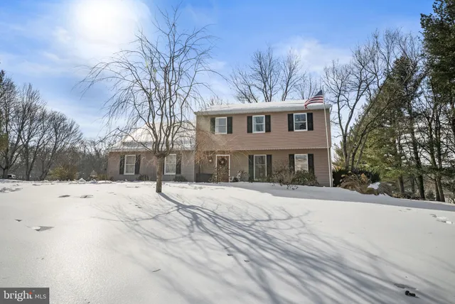 a front view of a house with a yard covered in snow