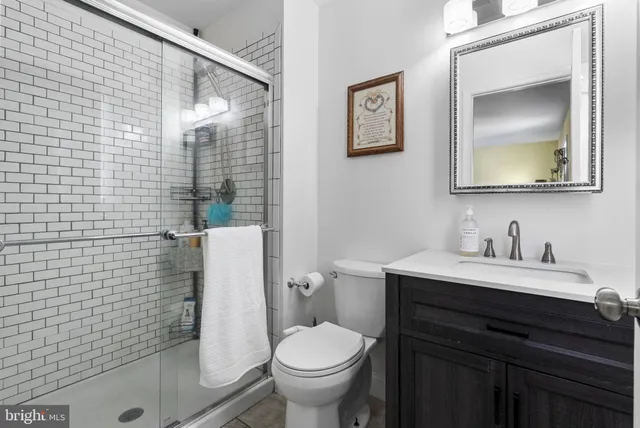 a bathroom with a toilet sink vanity and mirror
