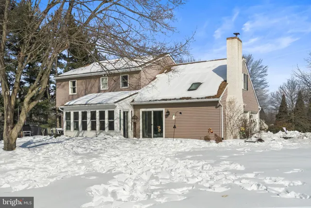 a front view of a house with a yard covered in snow