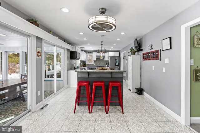 a kitchen with stainless steel appliances kitchen island granite countertop a refrigerator and a sink