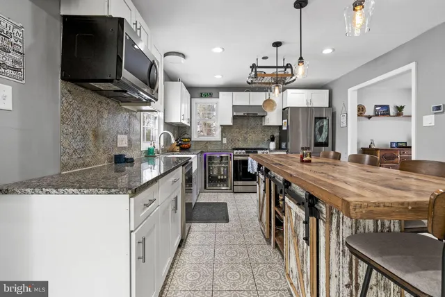 a kitchen with stainless steel appliances granite countertop a sink a stove and a wooden cabinets