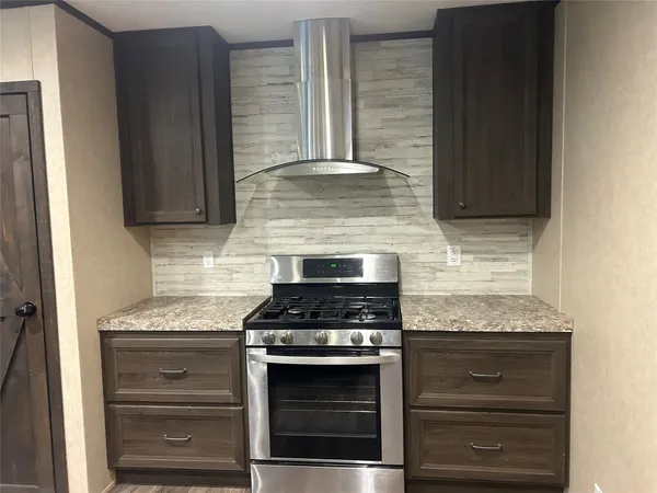 a kitchen with granite countertop cabinets and steel stove