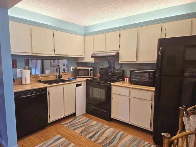 a kitchen with a refrigerator stove and white cabinets