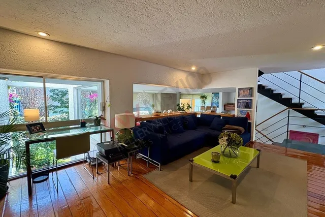 a living room with furniture a wooden floor and next to a window
