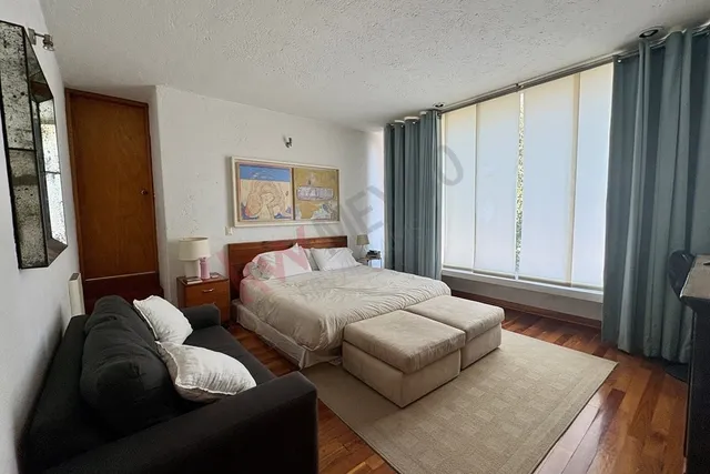 a bedroom with furniture and a large window