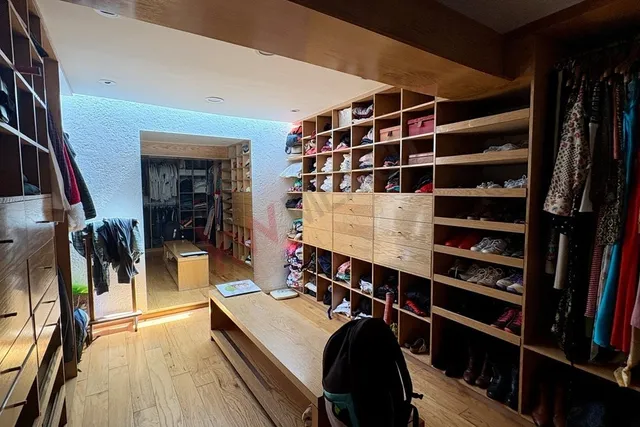 a view of walk in closet with clothes and shoes