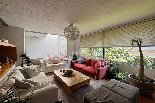 a living room with furniture a chandelier and a flat screen tv