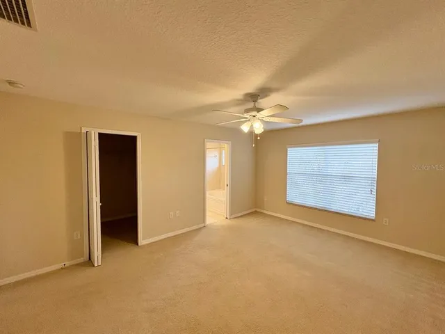 a view of an empty room with a ceiling fan