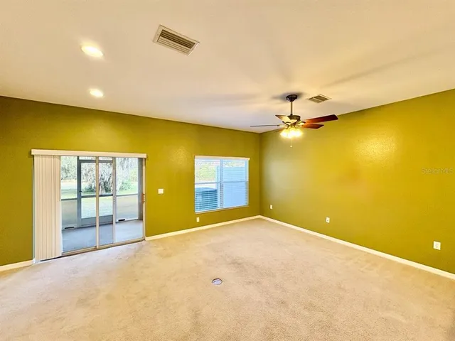 a view of a big room with wooden floor and windows