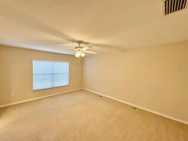 an empty room with a ceiling fan and a window
